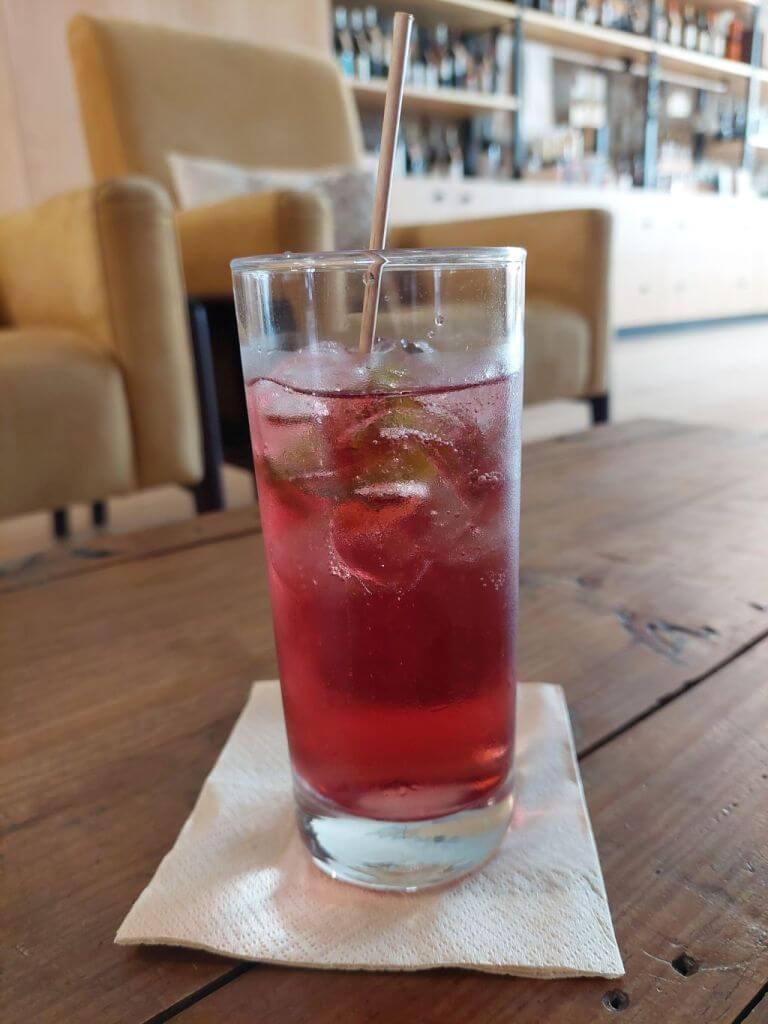 Long sklenice s růžovým portonicem na stole